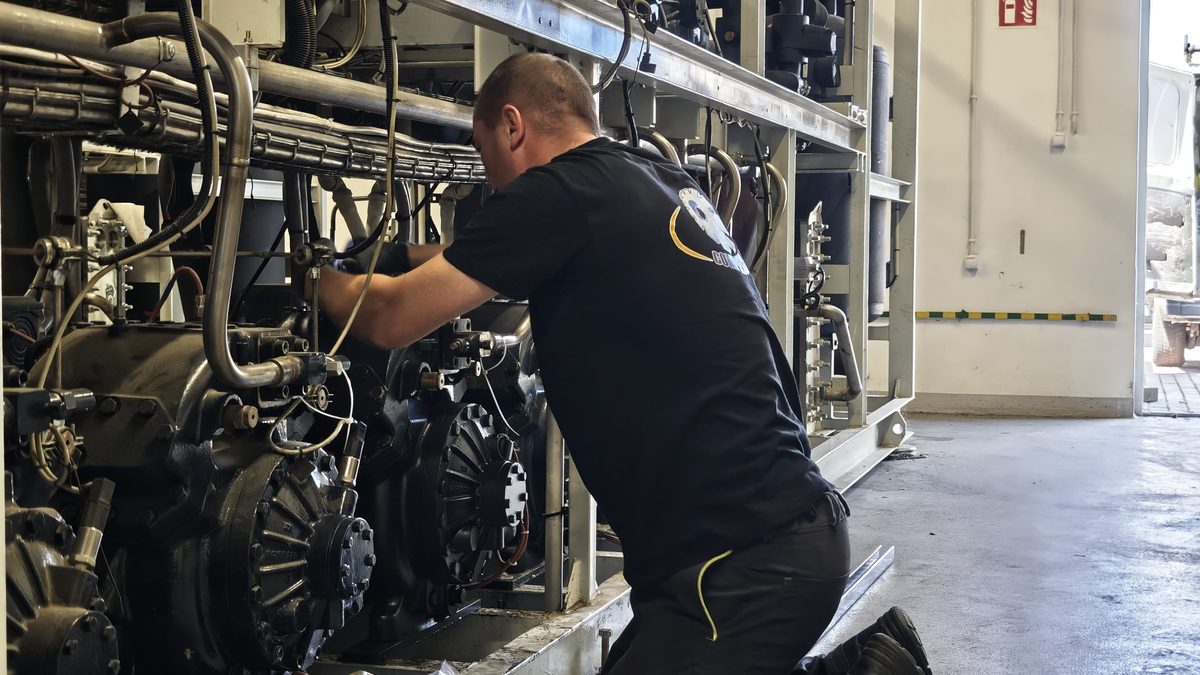 Technik Compressland przy sprężarce zamontowanej w agregacie na obiekcie