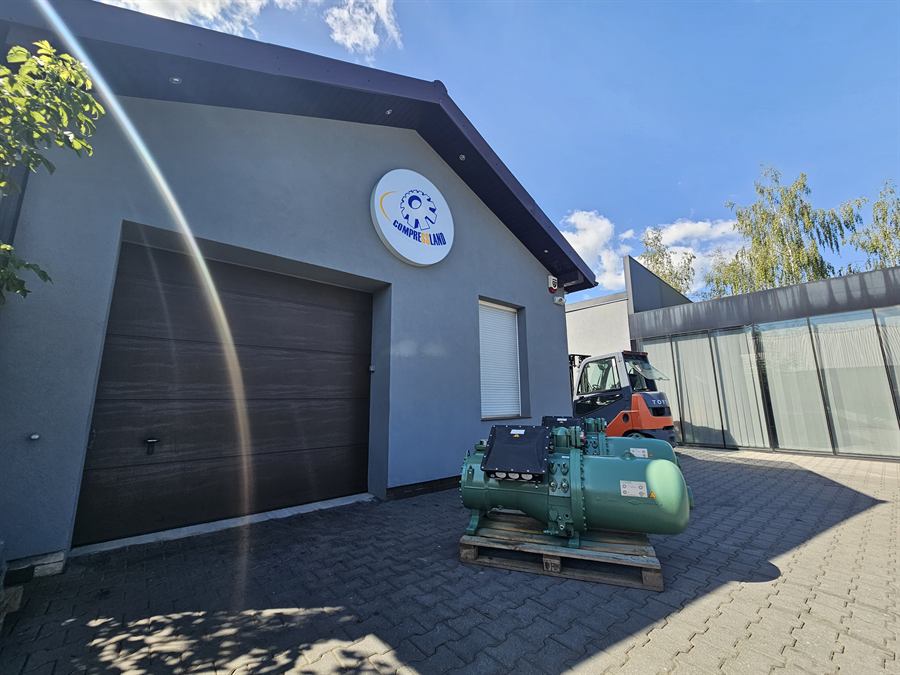 Zregenerowana sprężarka śrubowa na palecie przed magazynem Compressland